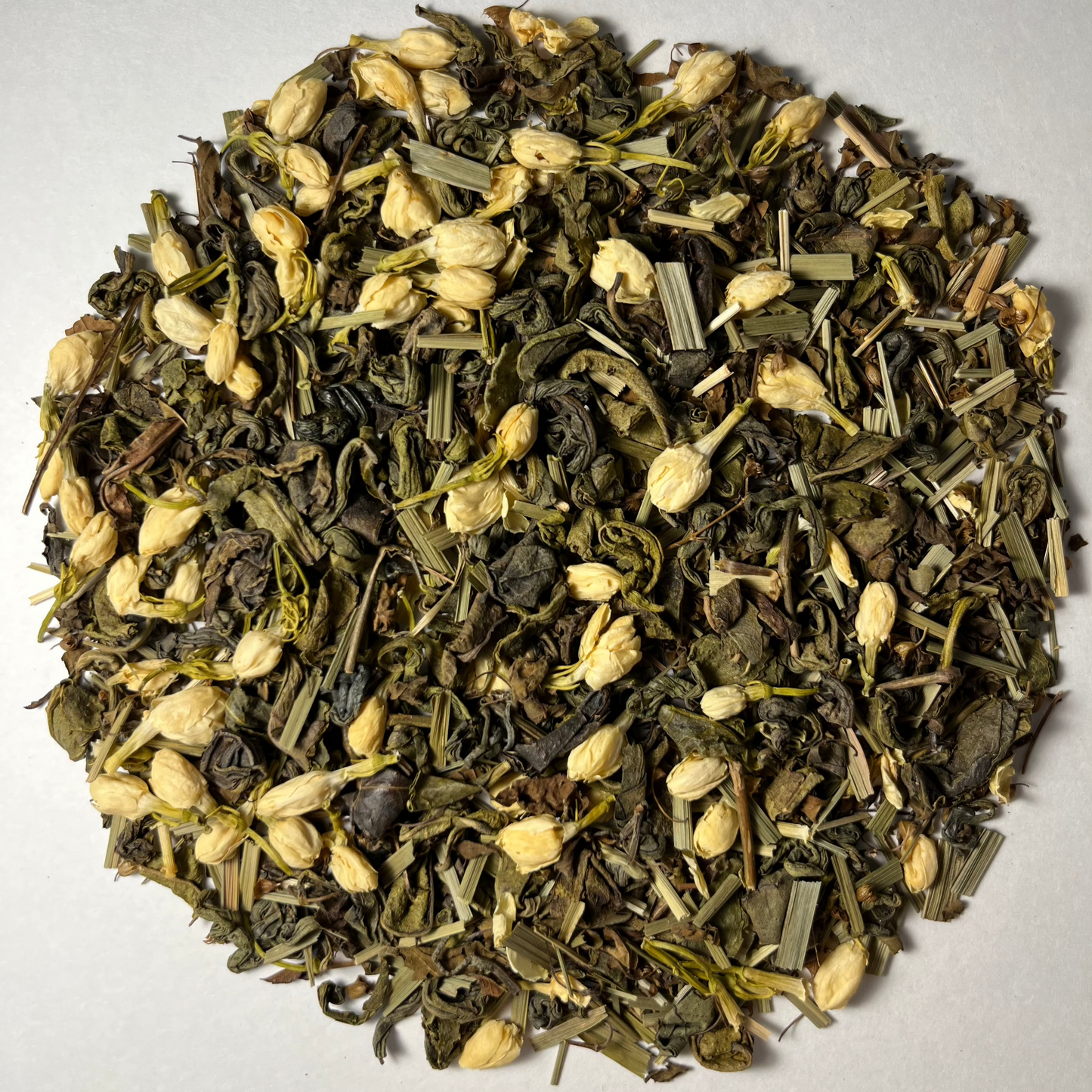 Emerald Bliss tea – Loose leaf blend featuring green tea, jasmine flowers, lemongrass, and tulsi, showcasing its vibrant, natural ingredients.